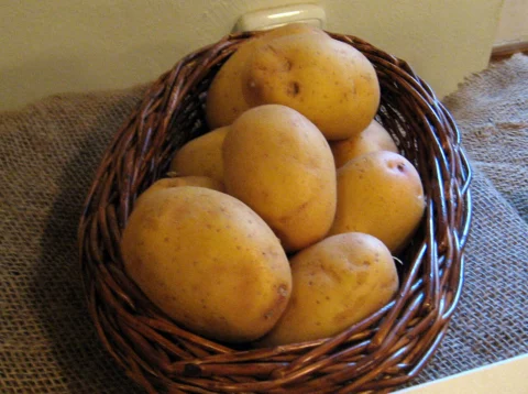 A wicker basket filled with potatoes.