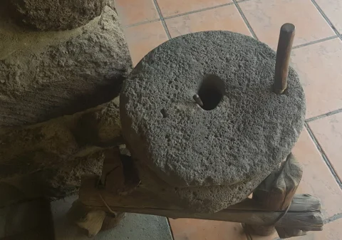 A round stone hand mill used for grinding grain.